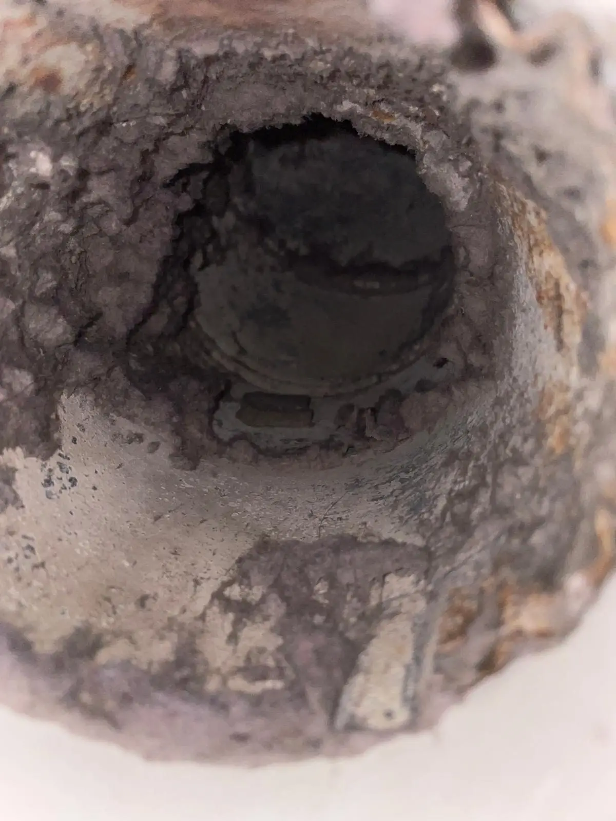 Dryer duct with heavy lint buildup before cleaning in Uptown Houston