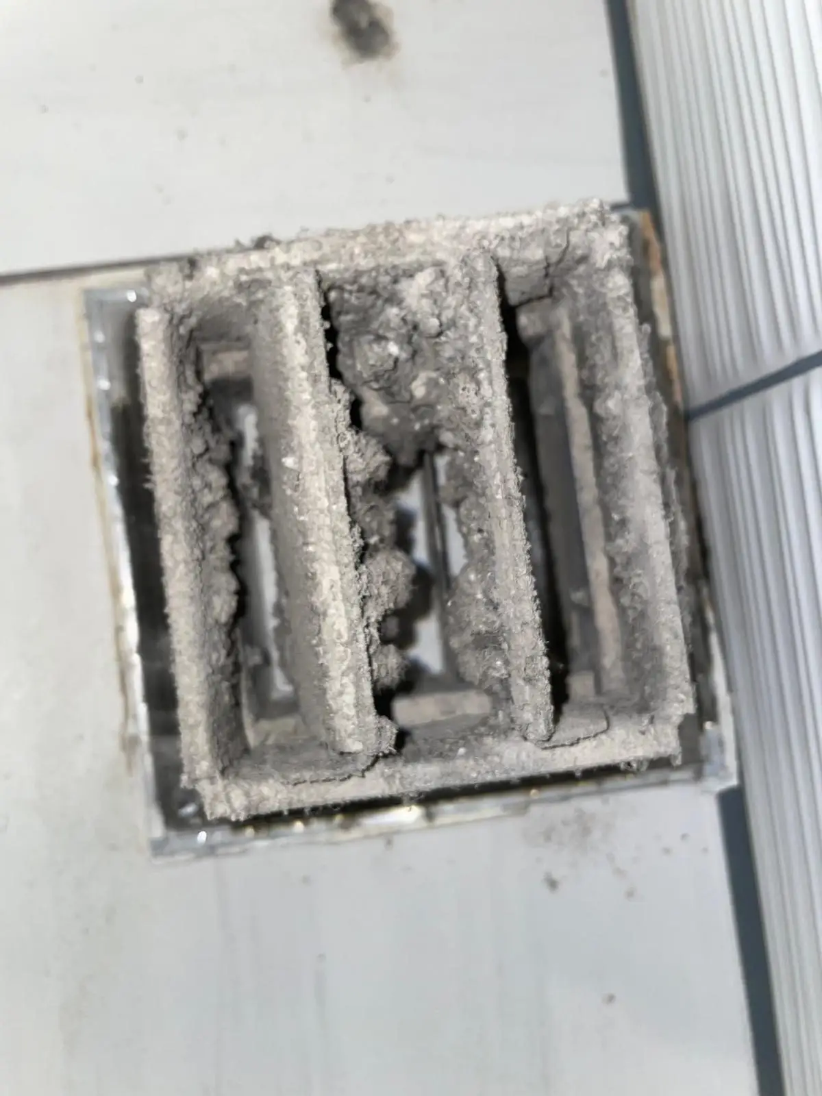 Dryer vent grille caked with lint before cleaning, Uptown Houston