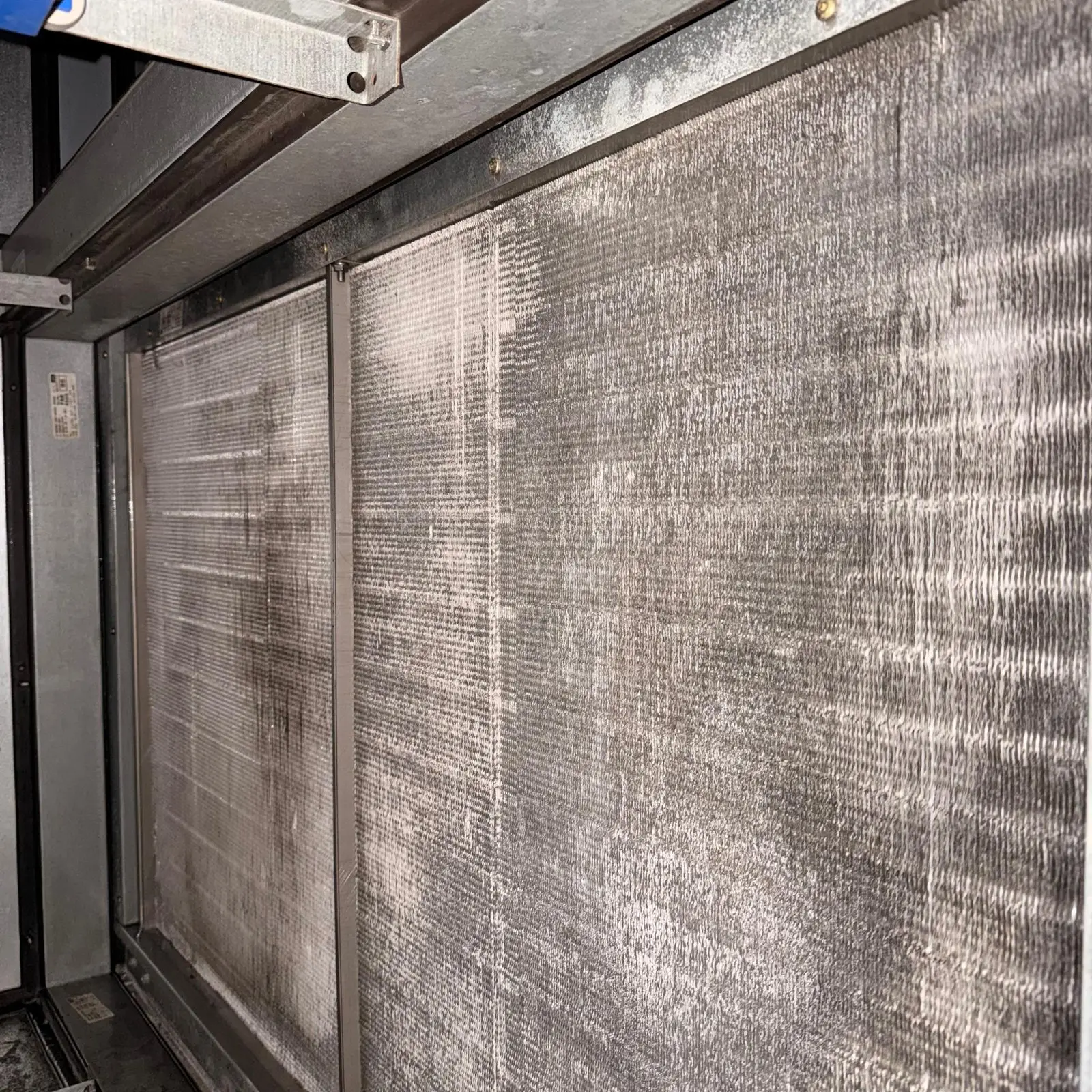 Heavy dust buildup across a commercial evaporator coil face in Katy, TX