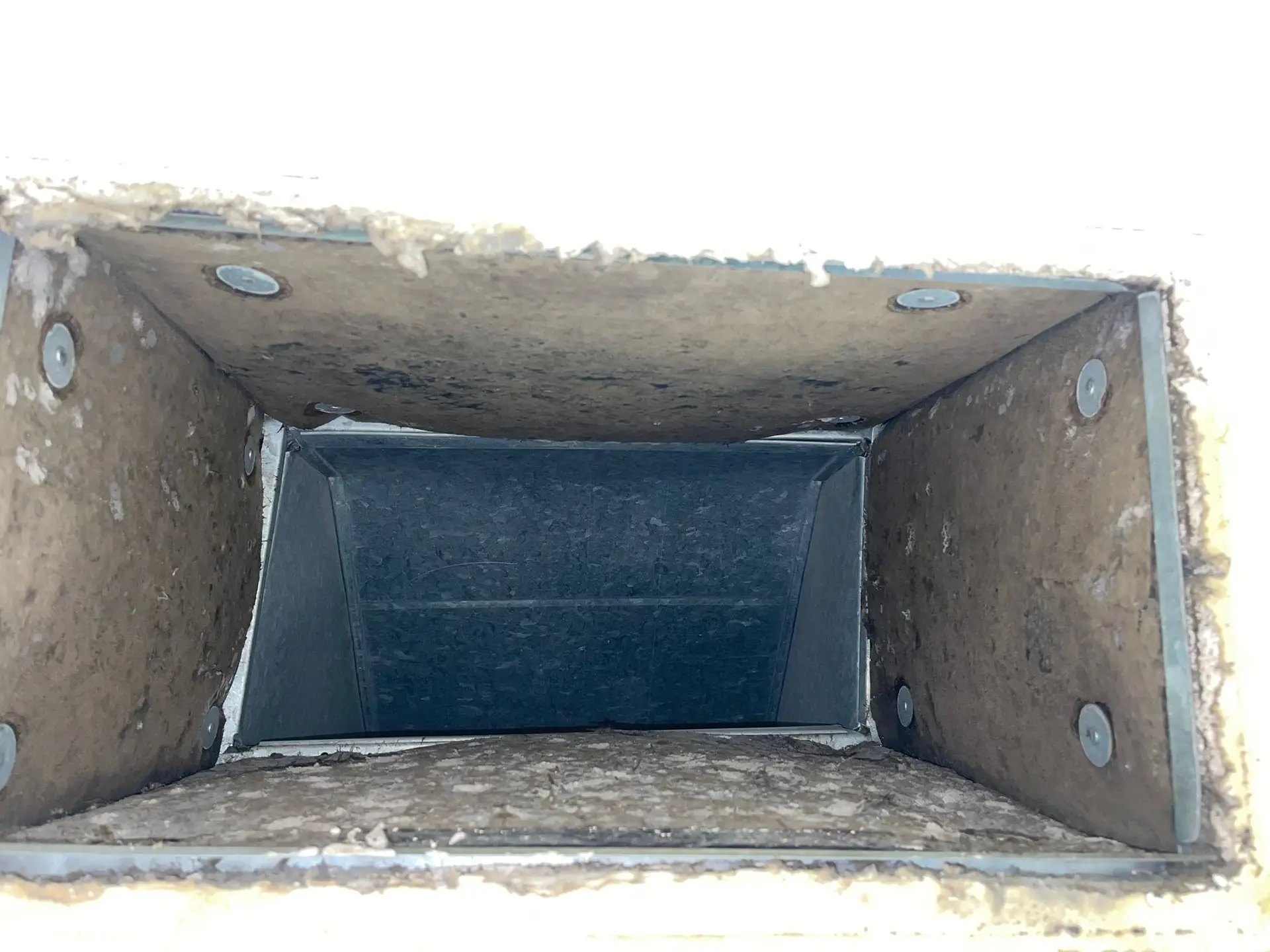 Dust-coated supply duct boot before commercial cleaning