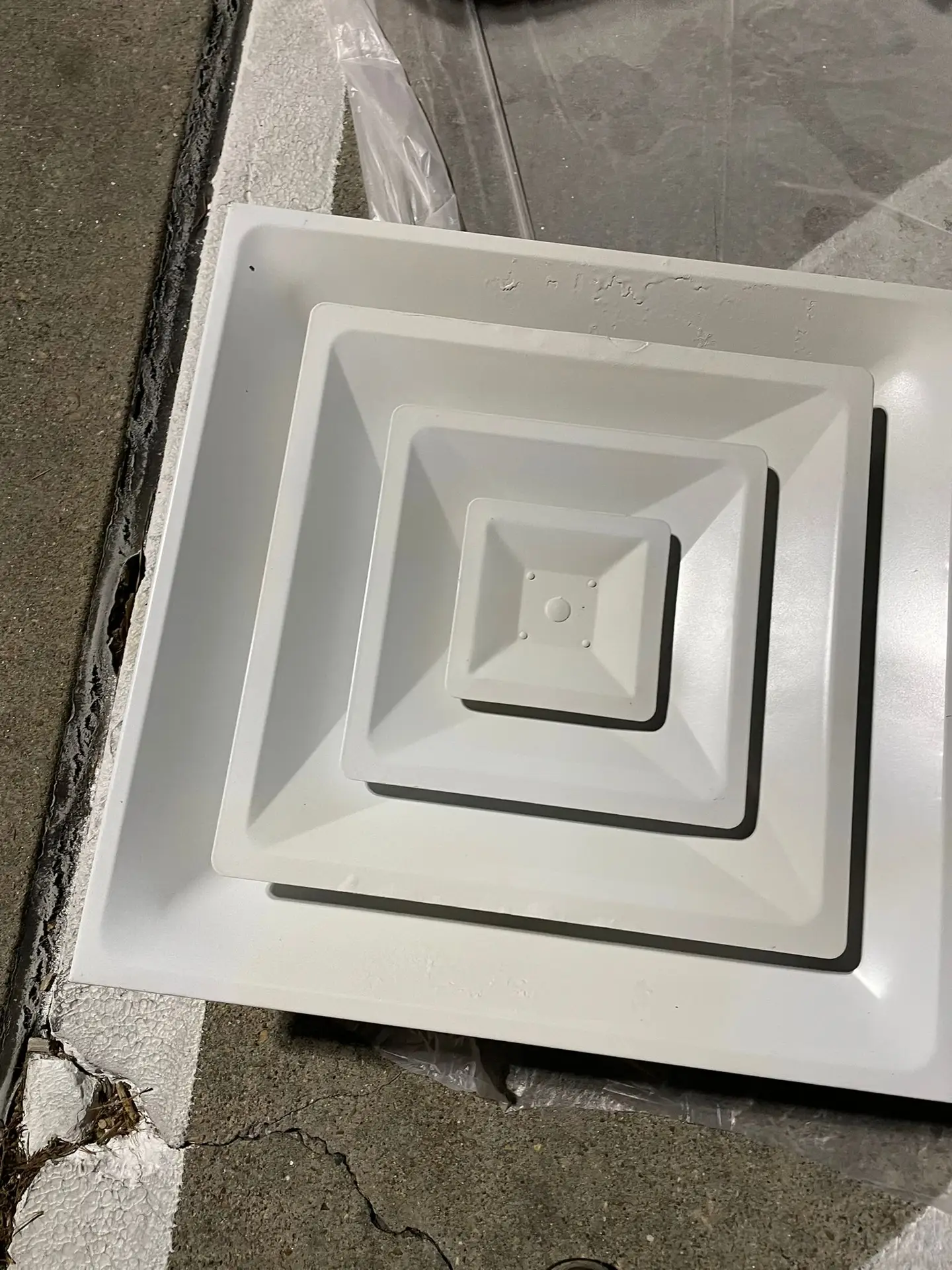Close-up of a repainted ceiling diffuser after commercial duct service