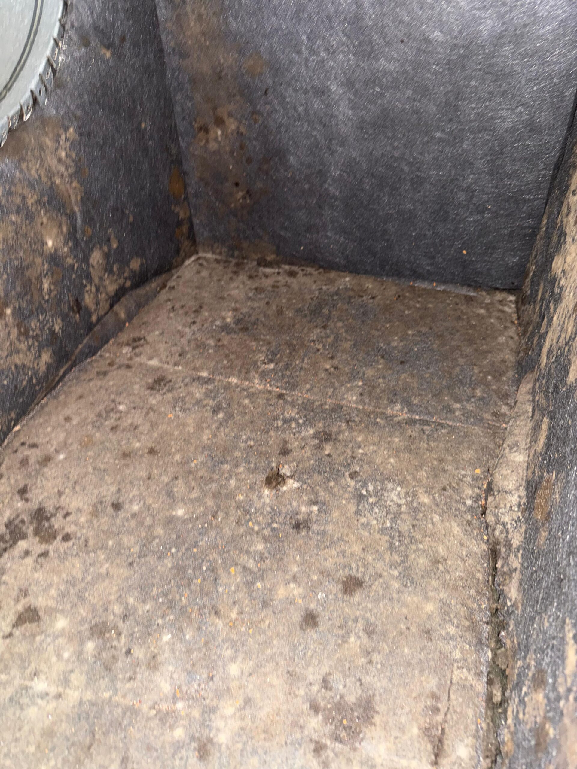 Heavy dust buildup inside an air duct plenum corner before professional cleaning in Magnolia TX