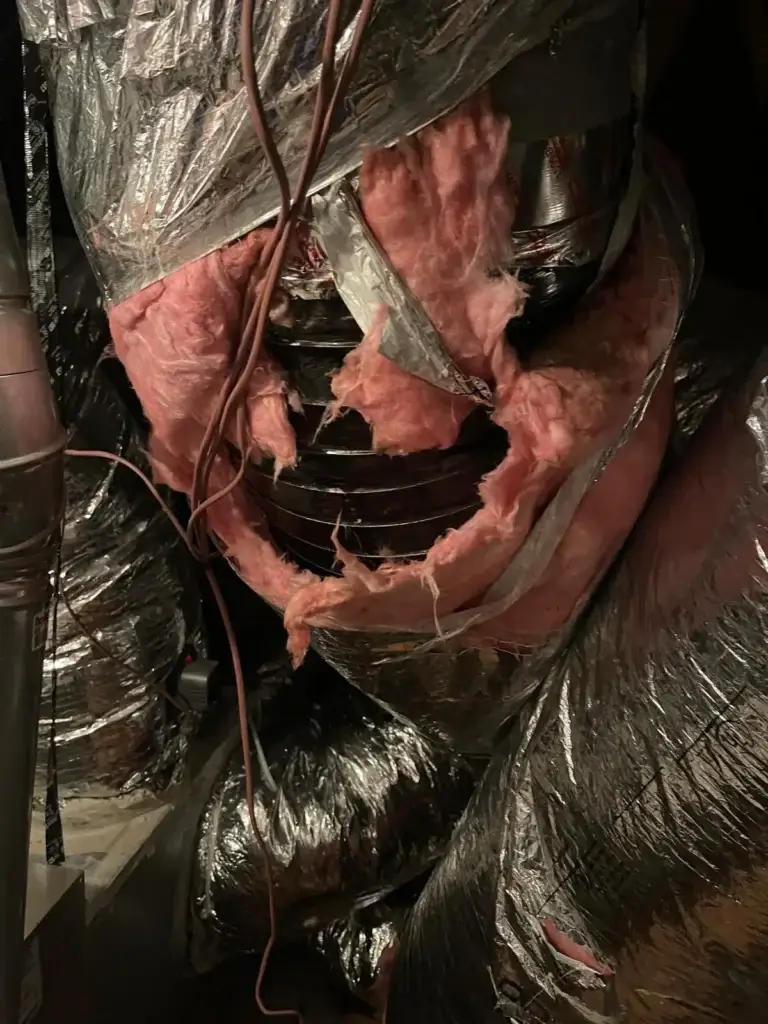 Supply duct connection stuffed with fiberglass instead of sealed, found in a Bellaire, TX attic
