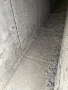 Heavy lint buildup packed along the floor of a commercial dryer exhaust duct at a Museum District property in Houston, TX 77004