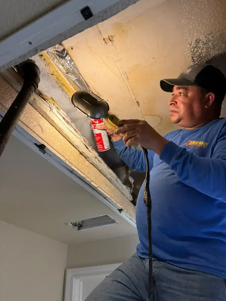 Technician servicing the plenum from the ceiling access in Katy, TX