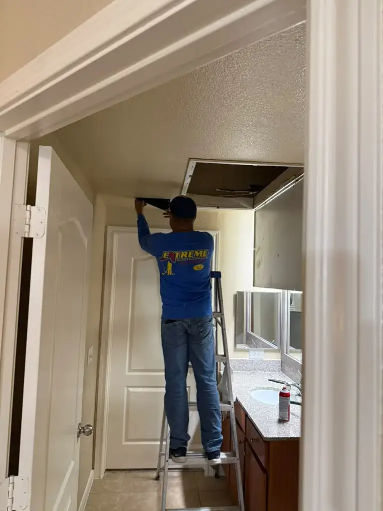 Technician working at the attic access during air duct cleaning in Katy, TX 77450