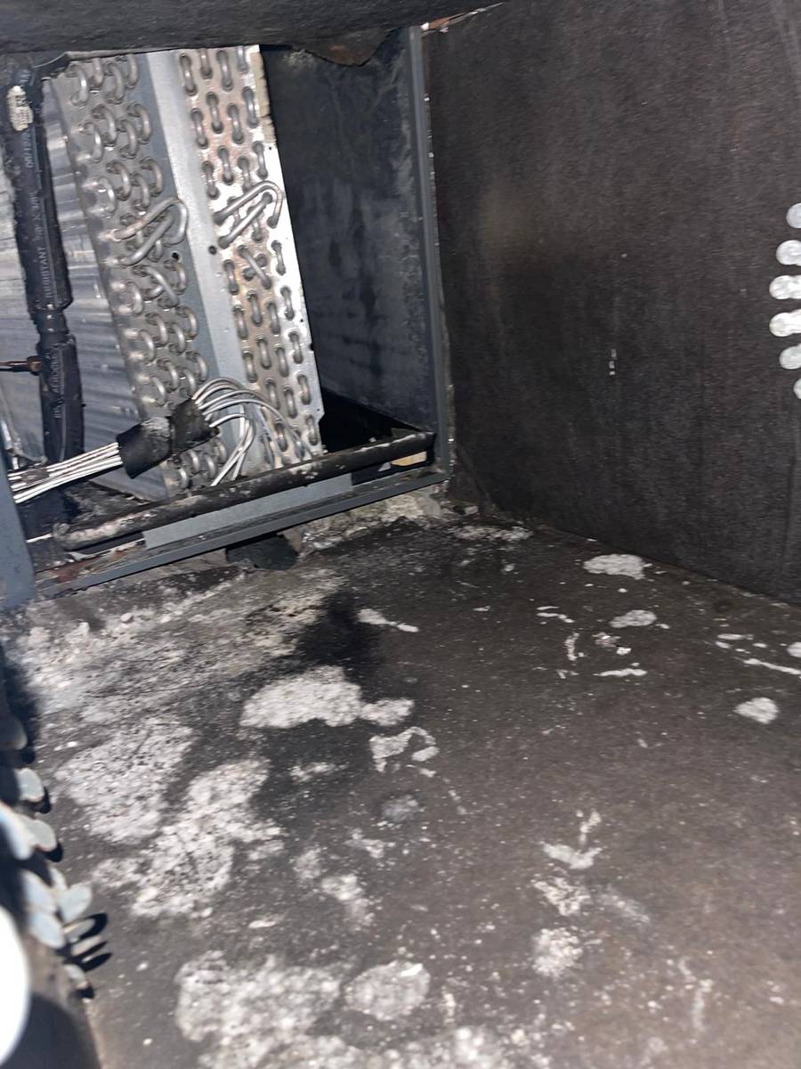 Dirty ductboard plenum floor with loose debris near the AC coil in Houston 77085
