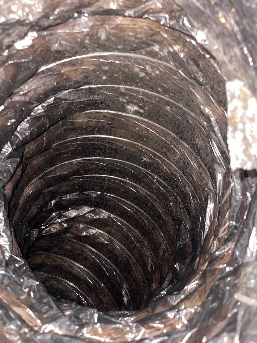 Dirty flex duct interior with dust buildup before air duct cleaning in Houston 77085