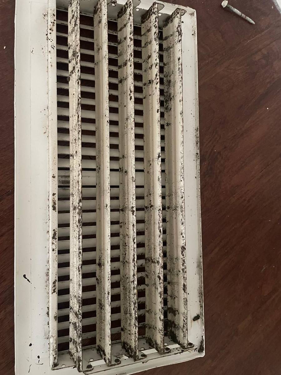 Dirty return air grille with dark buildup on the slats at an apartment in Montrose, Houston