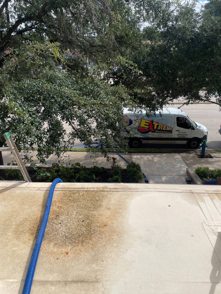 Dryer lint buildup on the exterior ledge below commercial dryer vent hoods in Houston 77057