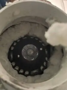 Lint-clogged dryer booster fan wheel before cleaning at a day spa in Tanglewood, Houston 77057