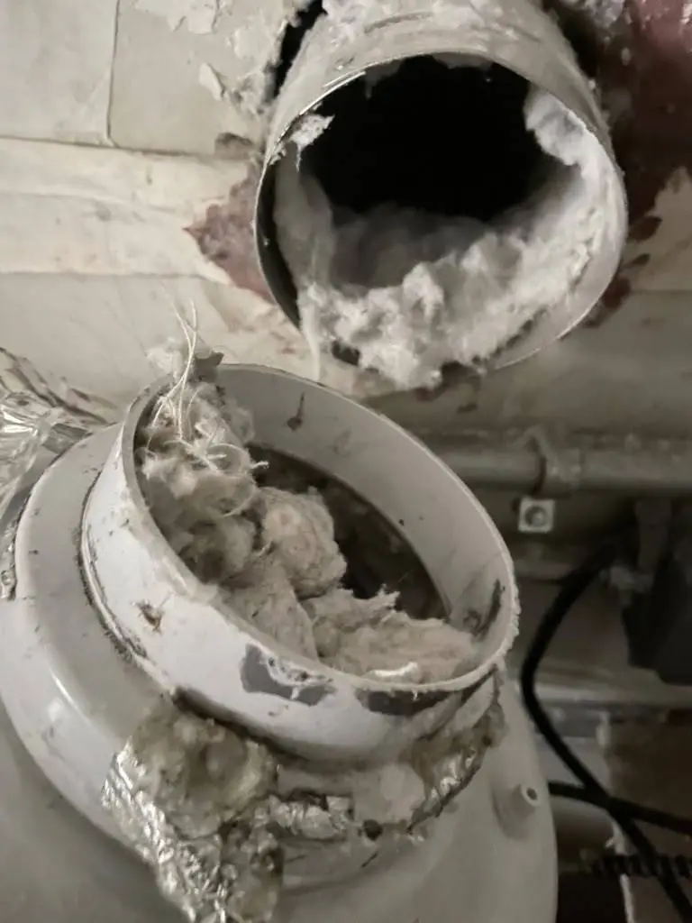 Lint-packed dryer booster fan housing found during commercial dryer vent cleaning in Houston